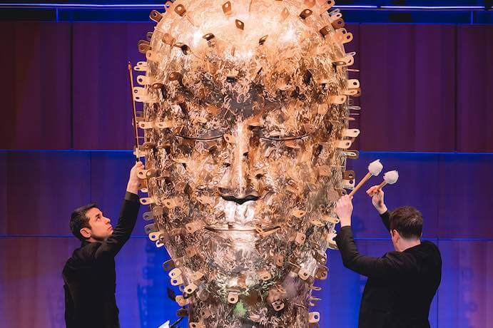 Andy Akiho performs "Sculptures" with the Omaha Symphony, featuring a large bronze head created by Jun Kaneko – Photo by Casey Wood