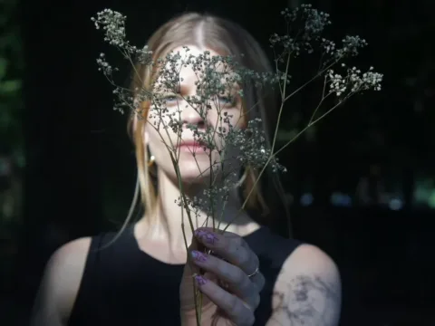 Laura Cocks holding a stalk of baby's breath in front of her face -- Photo by Samantha Riott